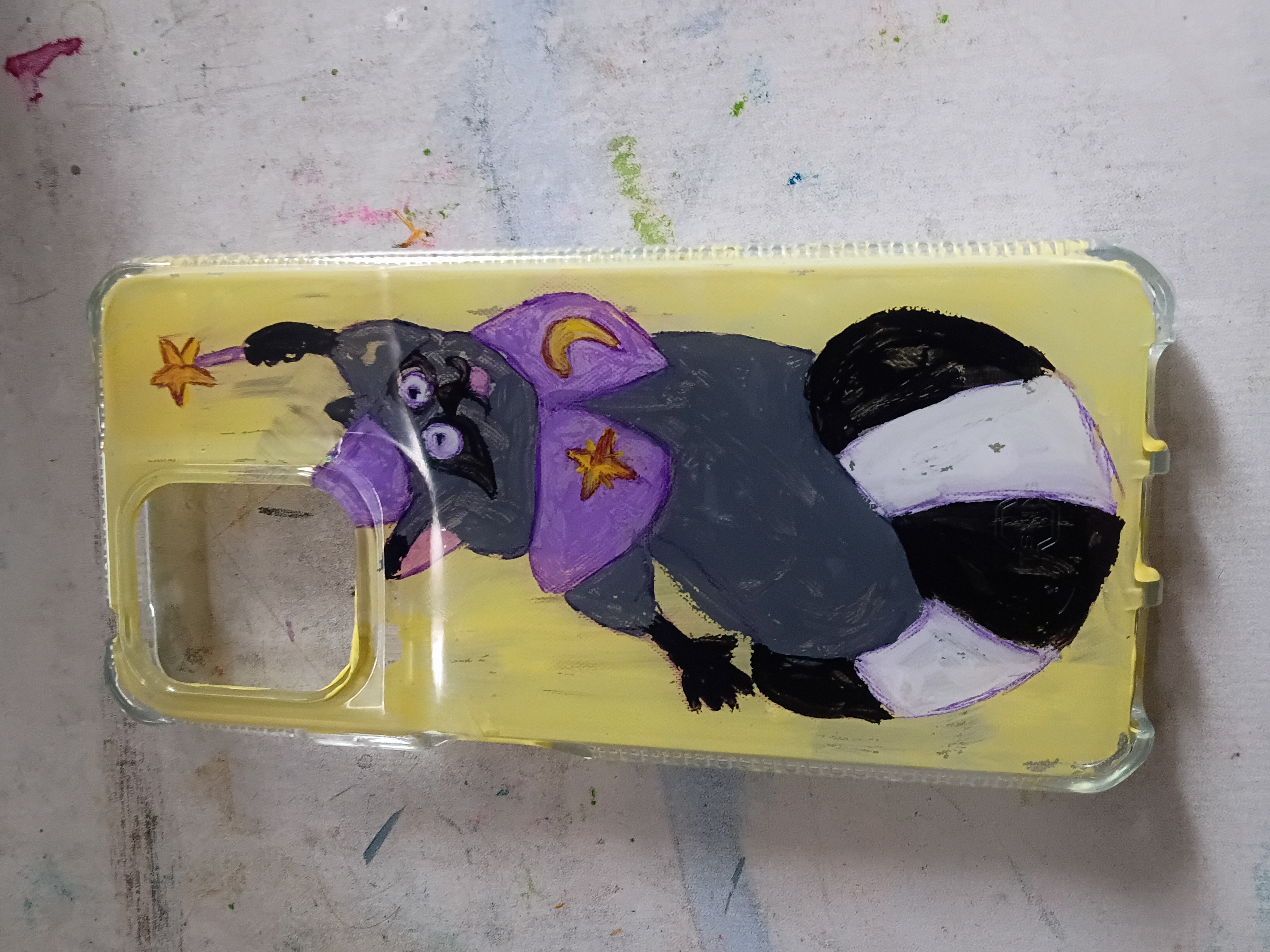 A plastic phone case with a painted cartoon racoon wearing a wizard cape and holding a wand high