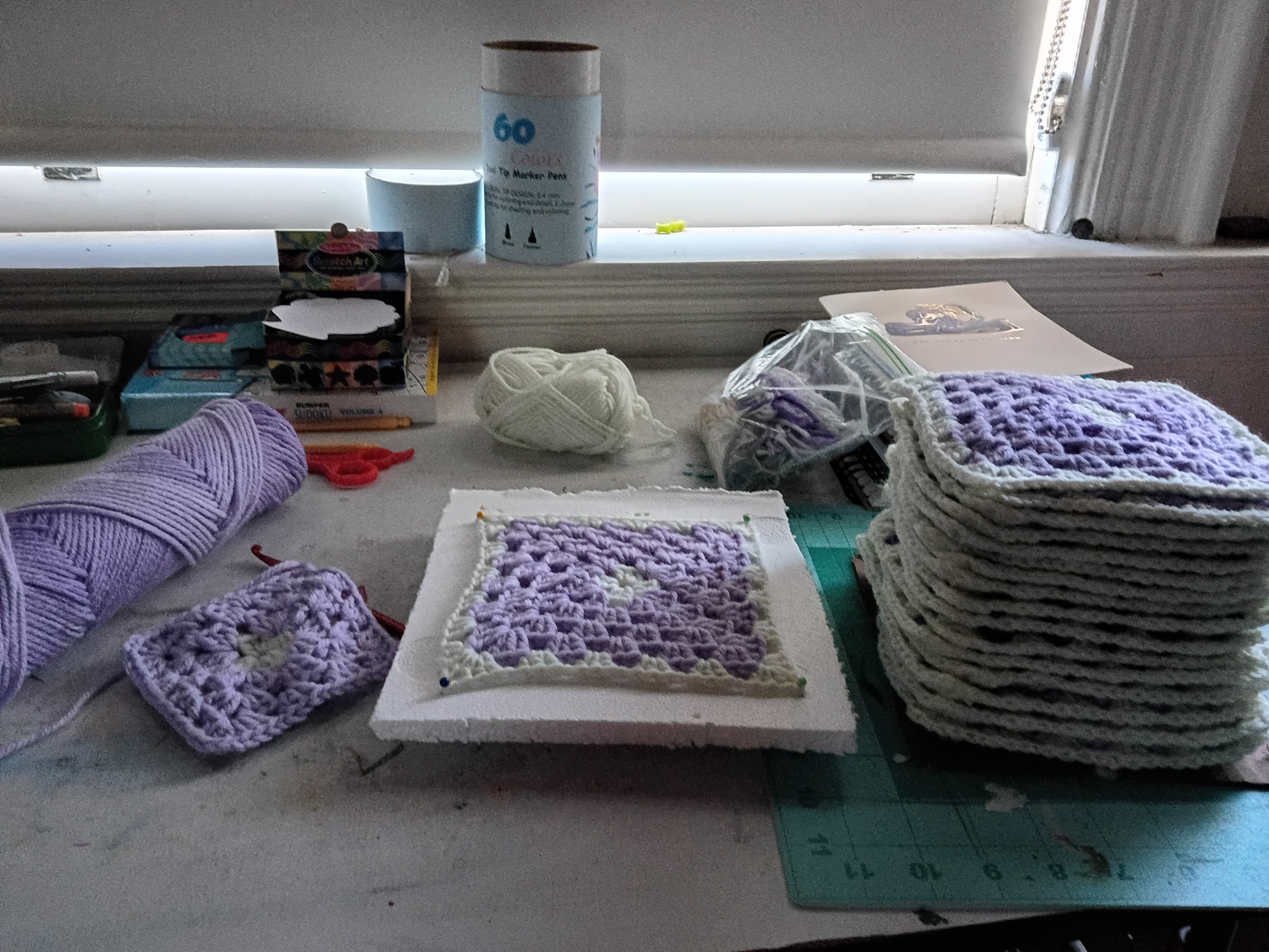 a stack of purple and white granny squares